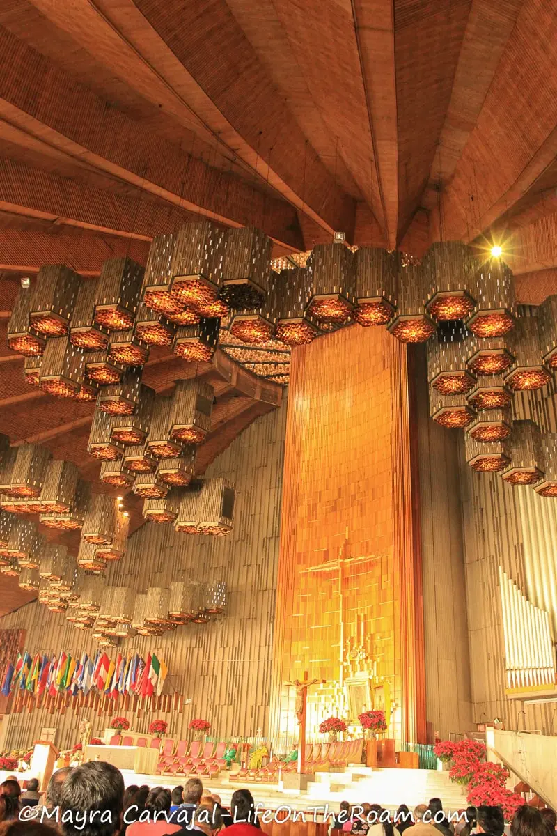 The sanctuary of a church with beehive-like lighting and wood finishes
