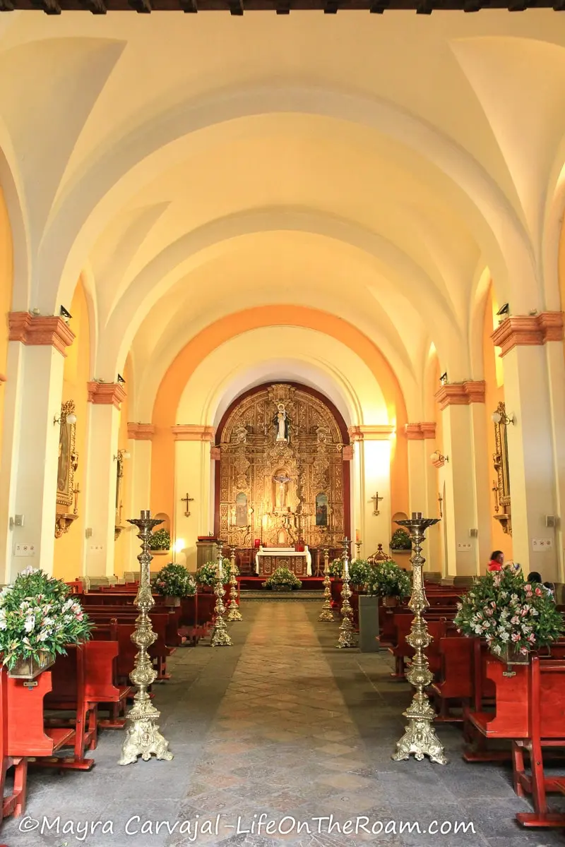 The main altar of a church at the end of a row of tall arches