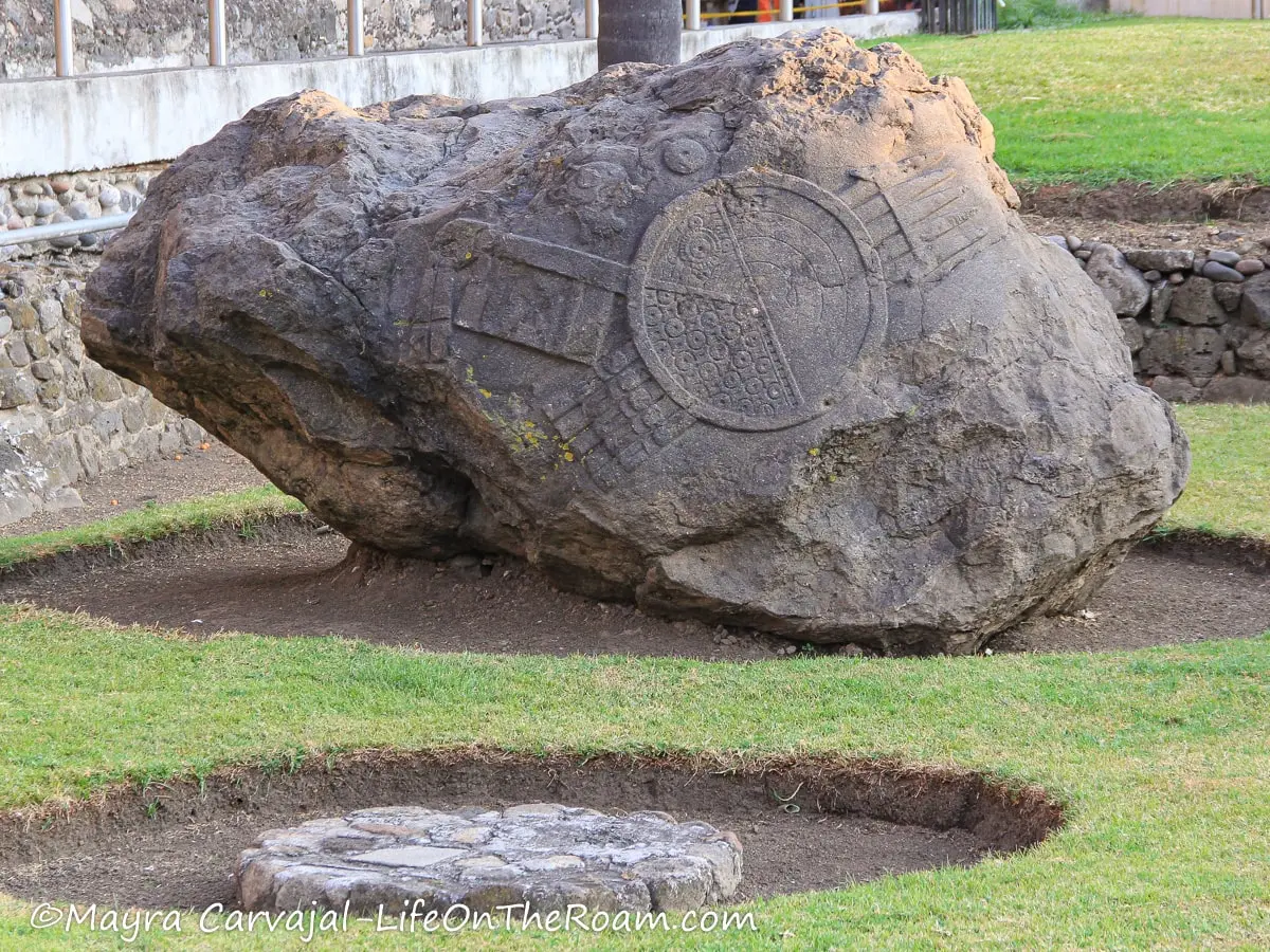 A large, ancient stone with carvings from an old civilization