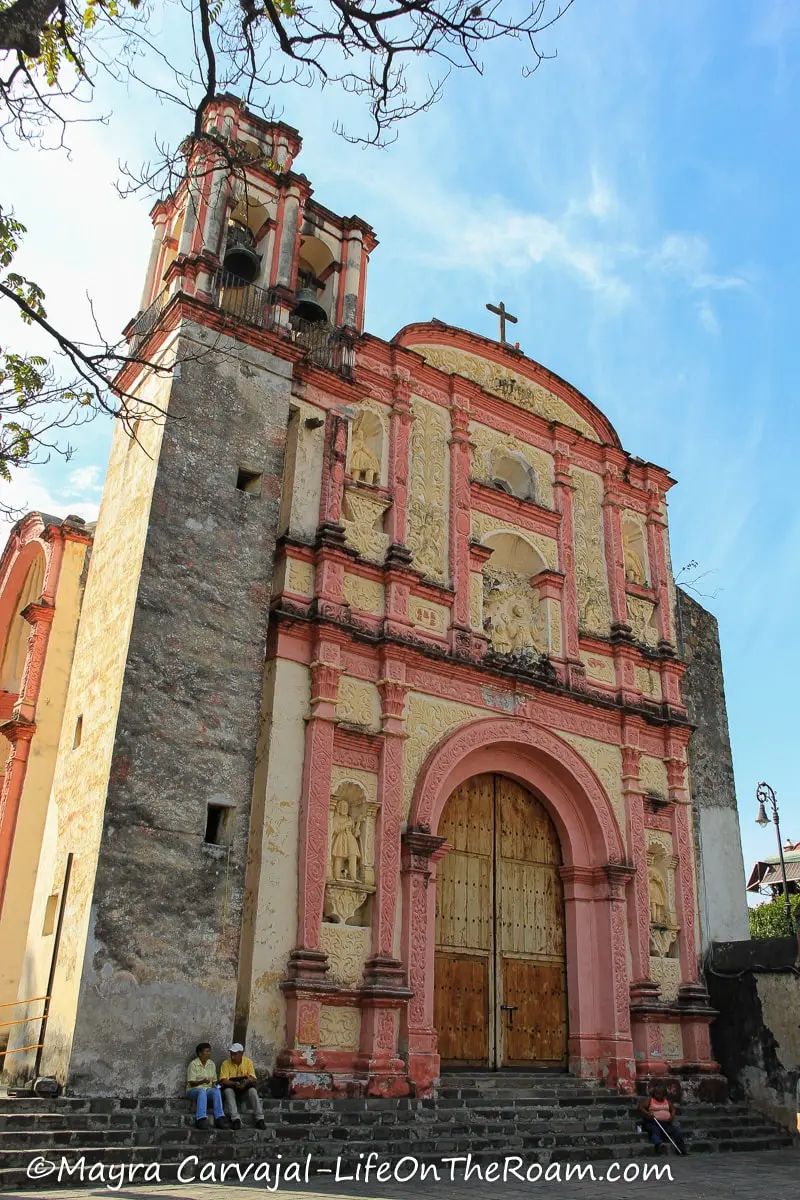 A Baroque-style church façade with details in yellow and pink
