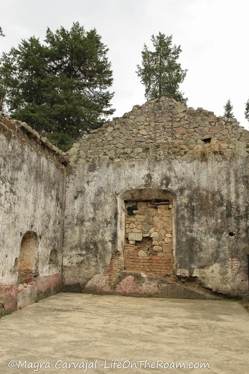 Ruins of a big room in an old convent with brick walls, without a roof