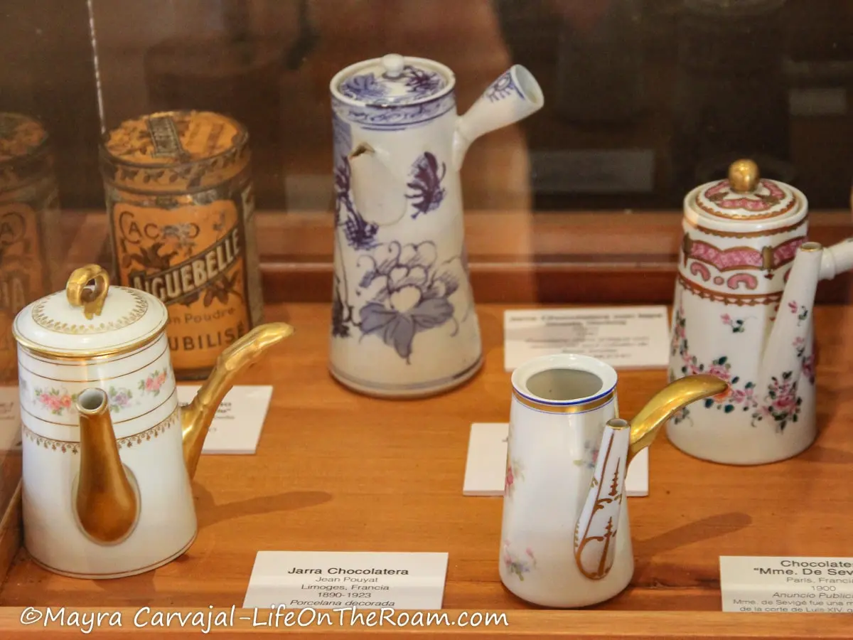 A tin and decorated porcelain jars to store and serve chocolate