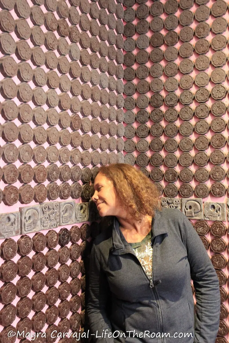 Mayra in a room covered with chocolate medallions