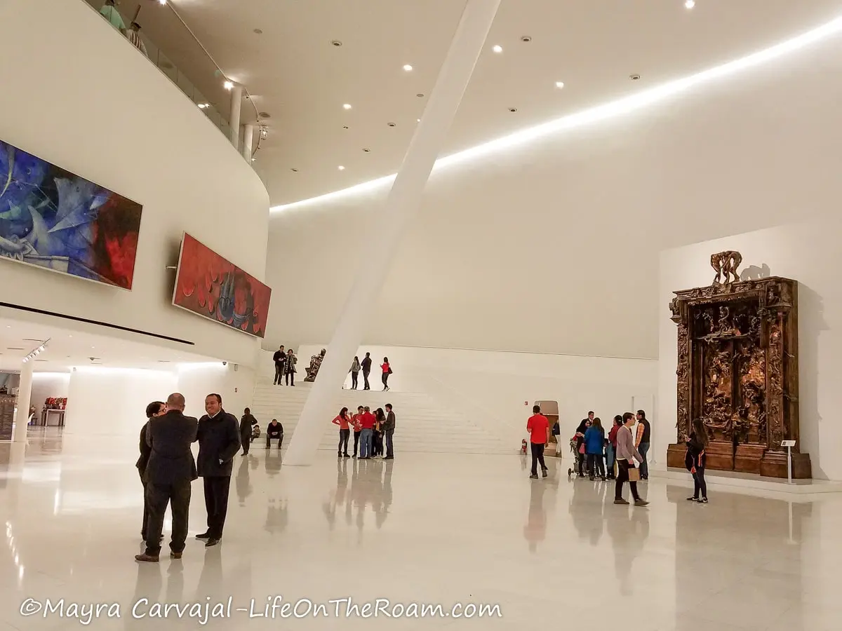 The lobby of a museum with tall white walls and art pieces
