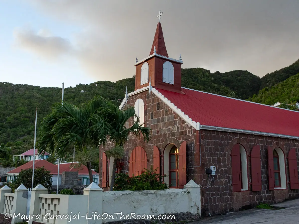 A church in Saba traditional style with reddish stones and a red slanted roof