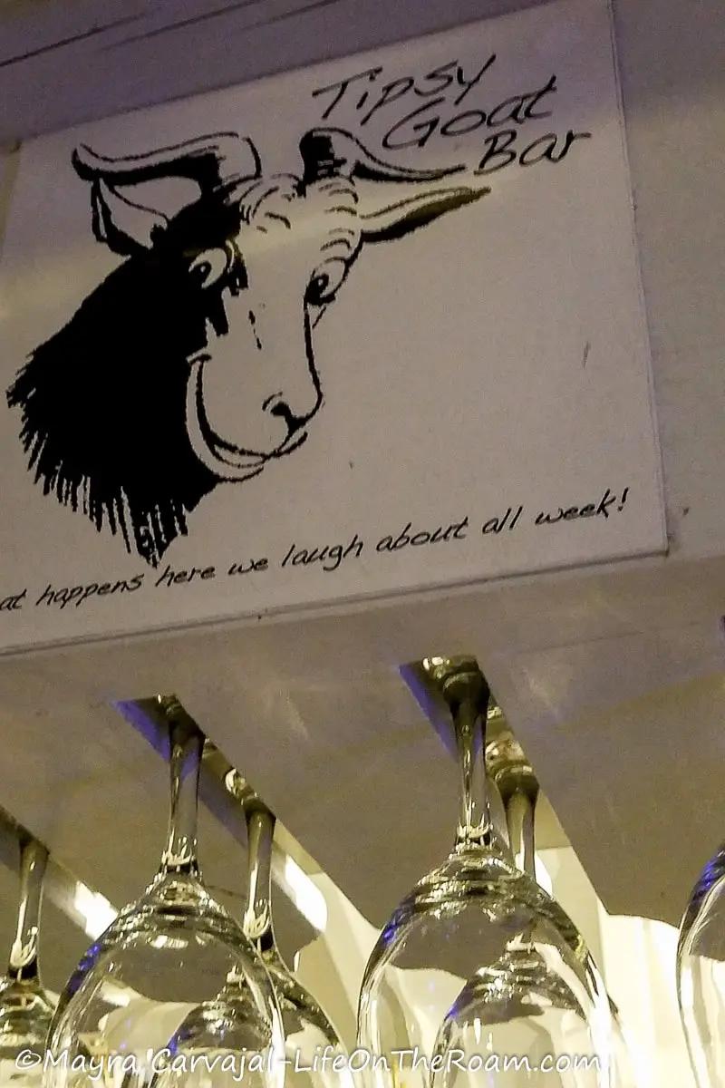 A sign at a bar on Saba with a drawing of a smiling goat and the name Tipsy Goat