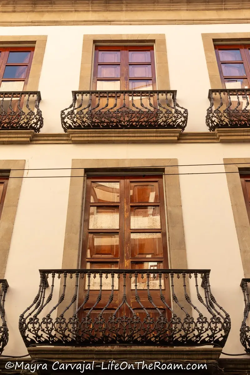 A series of wrought-iron balconies with wood and glass doors