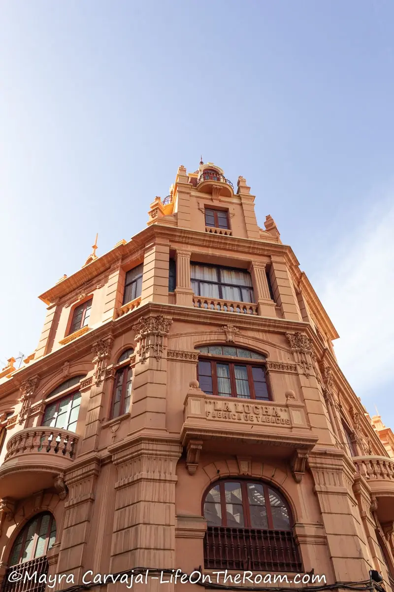 An eclectic style three-story historic building painted in pink