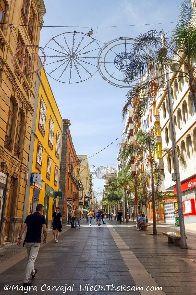 A pedestrian street with low-rise buildings painted in colours