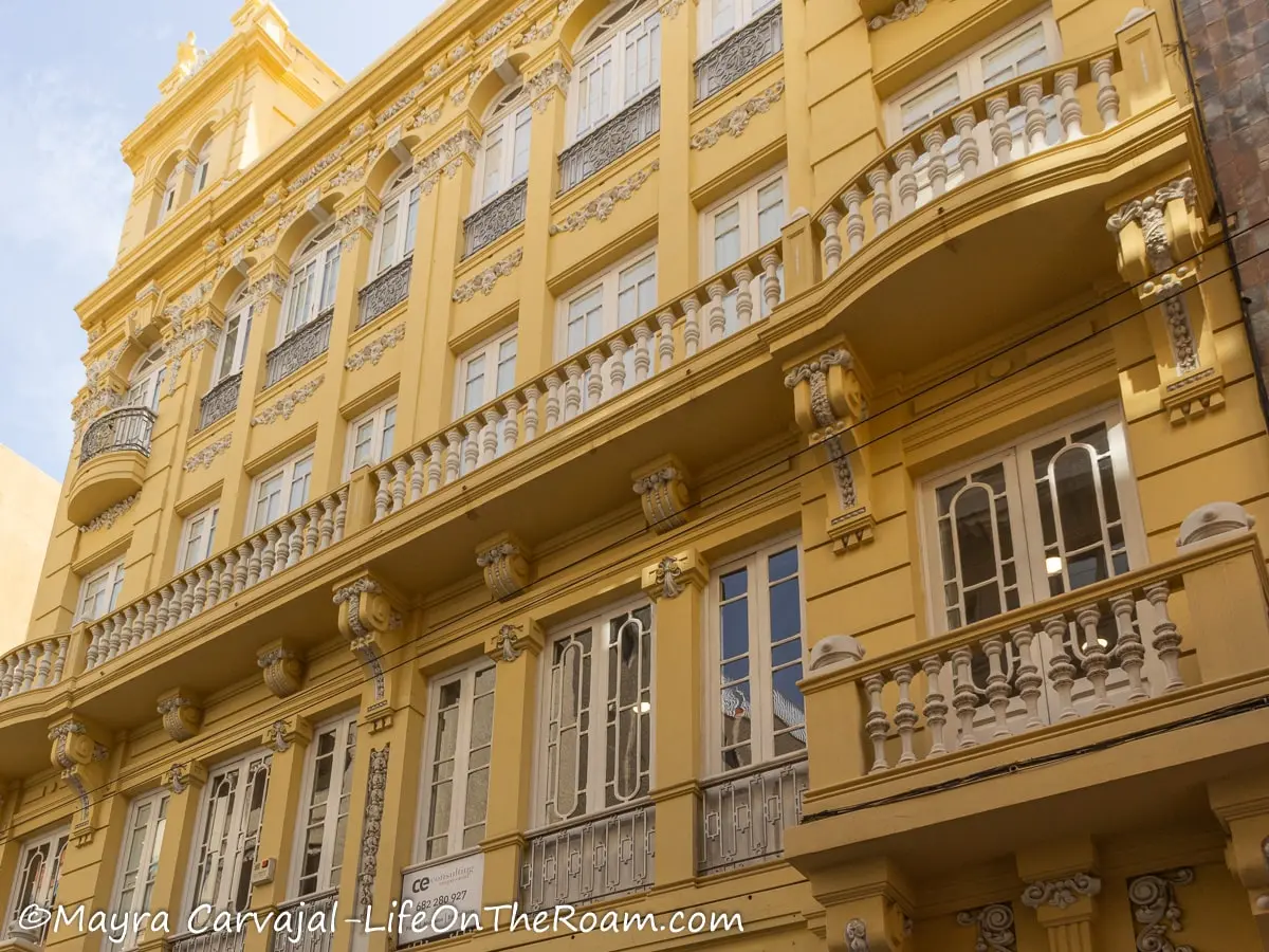 A yellow three-story building with Baroque-style elements