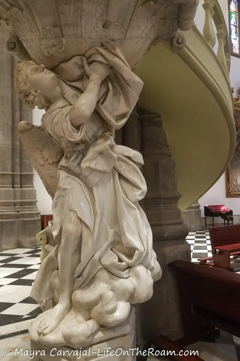 A marble sculpture under a spiral stair