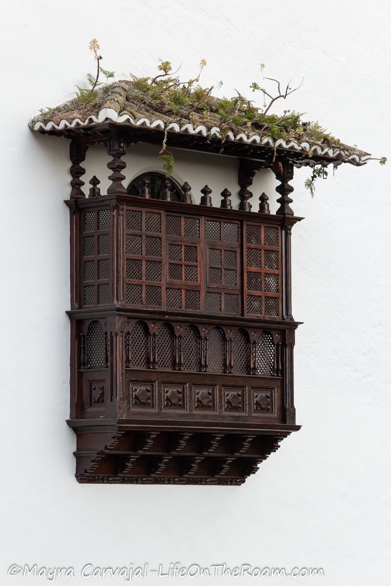 A highly elaborate balcony in dark wood with Mudejar style