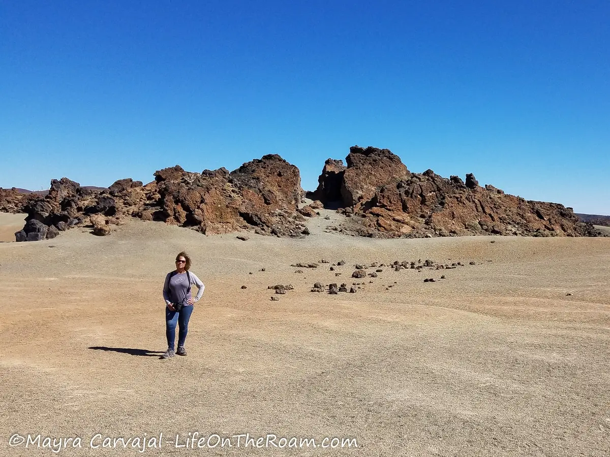 Mayra in a rocky trail with big rock formation in the background resembling a split mountain