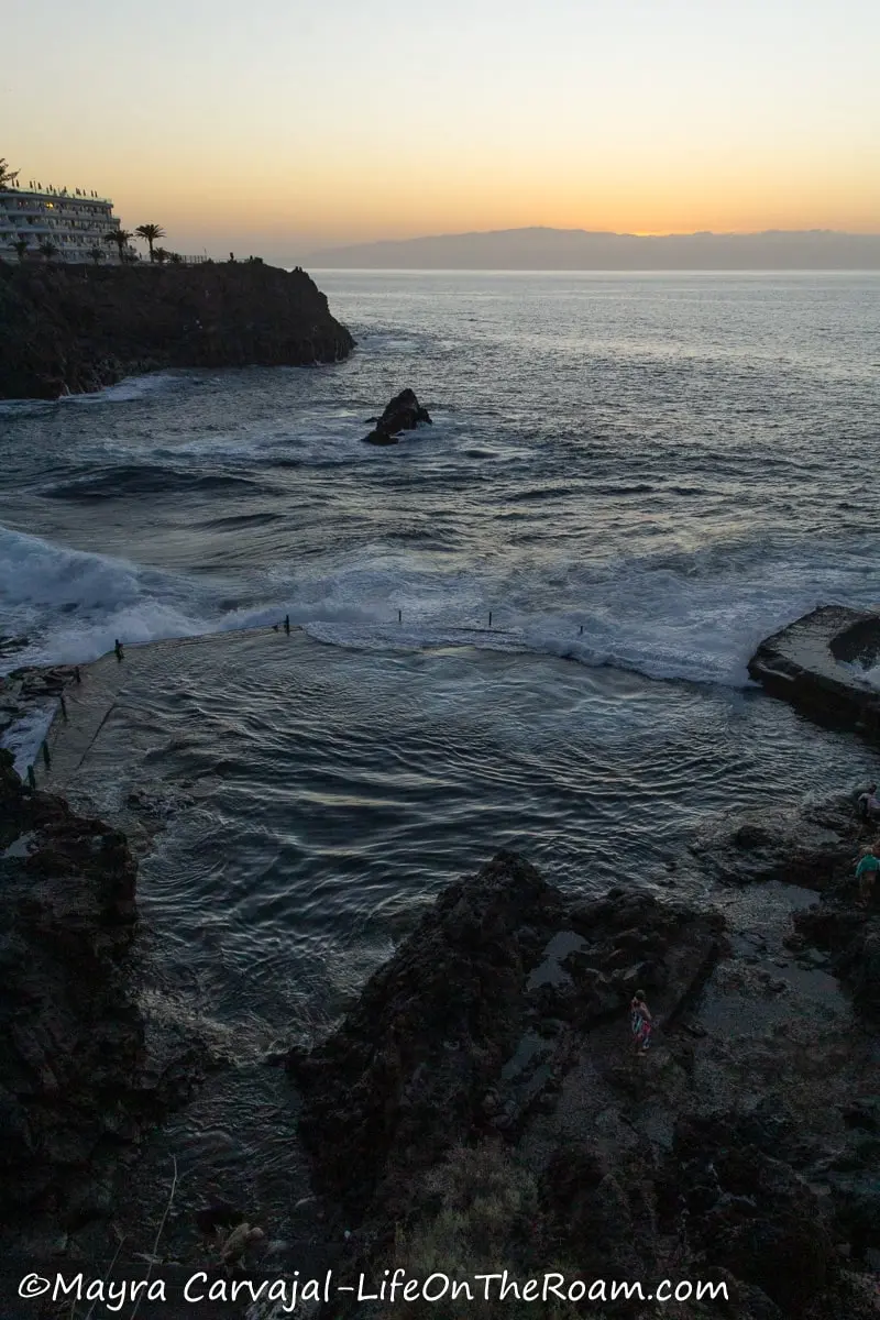 Rocks forming a natural pools in the sea at sunset