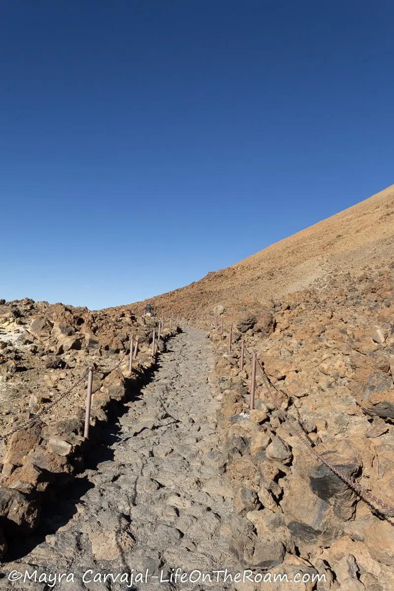 A trail with a rock path on the slopes of a volcano