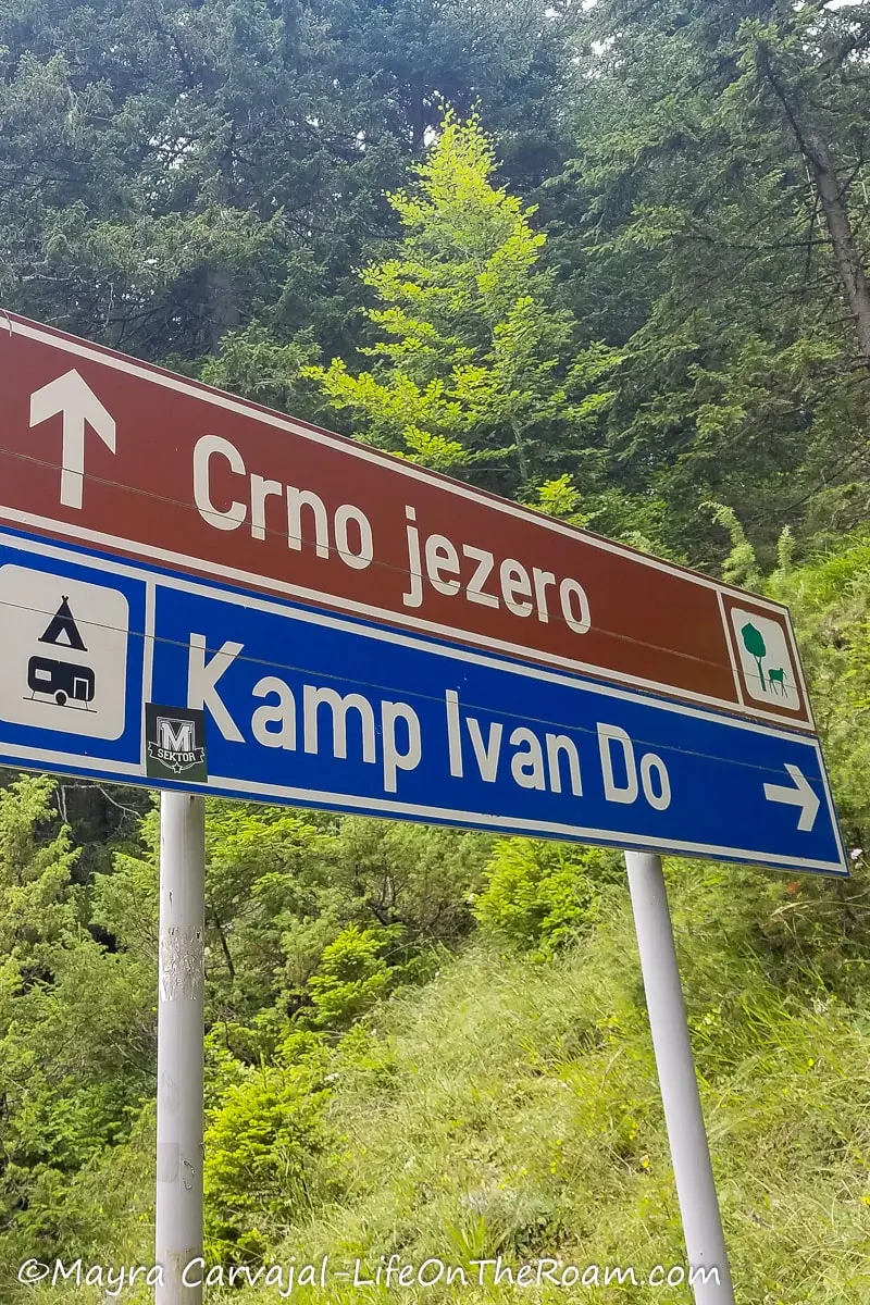 Two road signs reading "Crno Jazero" and "Kamp Ivan Do"