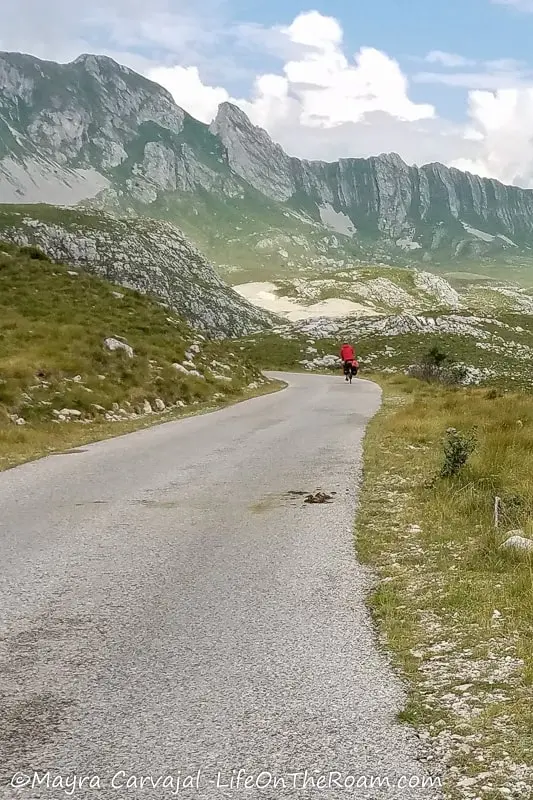 A biker on a paved road in the mountains