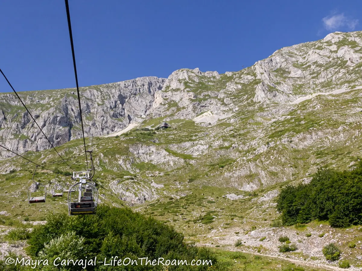 View of a mountain partially covered with grasses from a ski lift