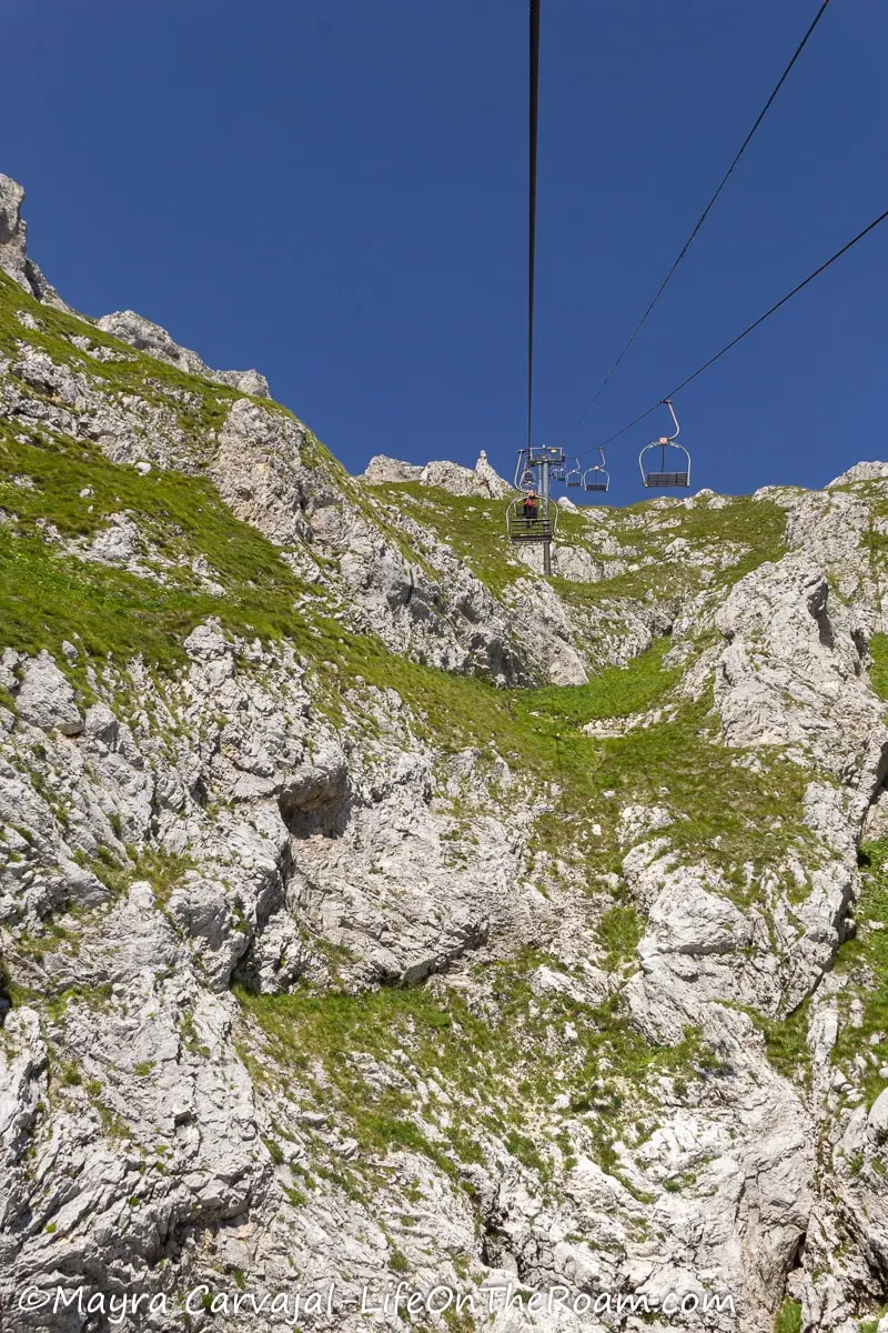 A ski lift going up on a steep mountain slope