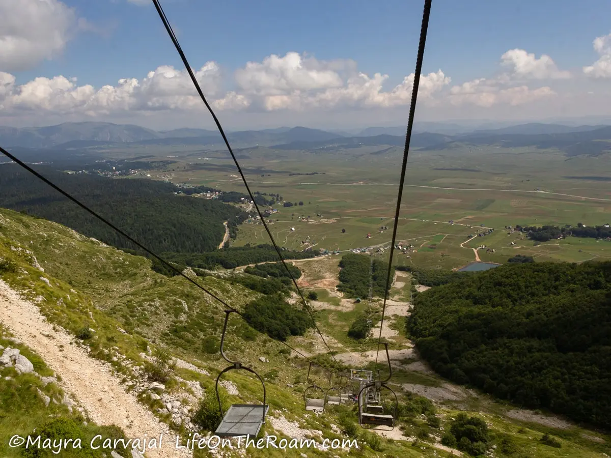 View of a valley from a ski lift, closer to the ground