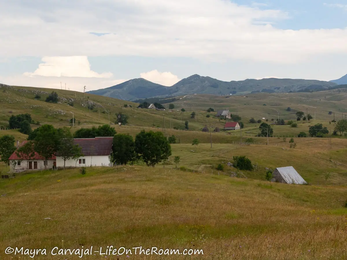 A small rural village in the green hills with mountains in the background