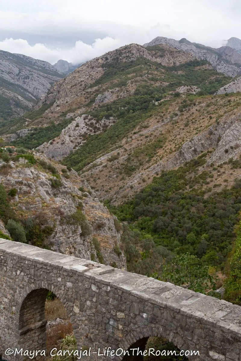 An old aqueduct with mountains in the background