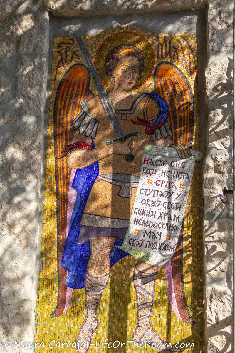 A mosaic depicting an angel holding a scroll with scriptures