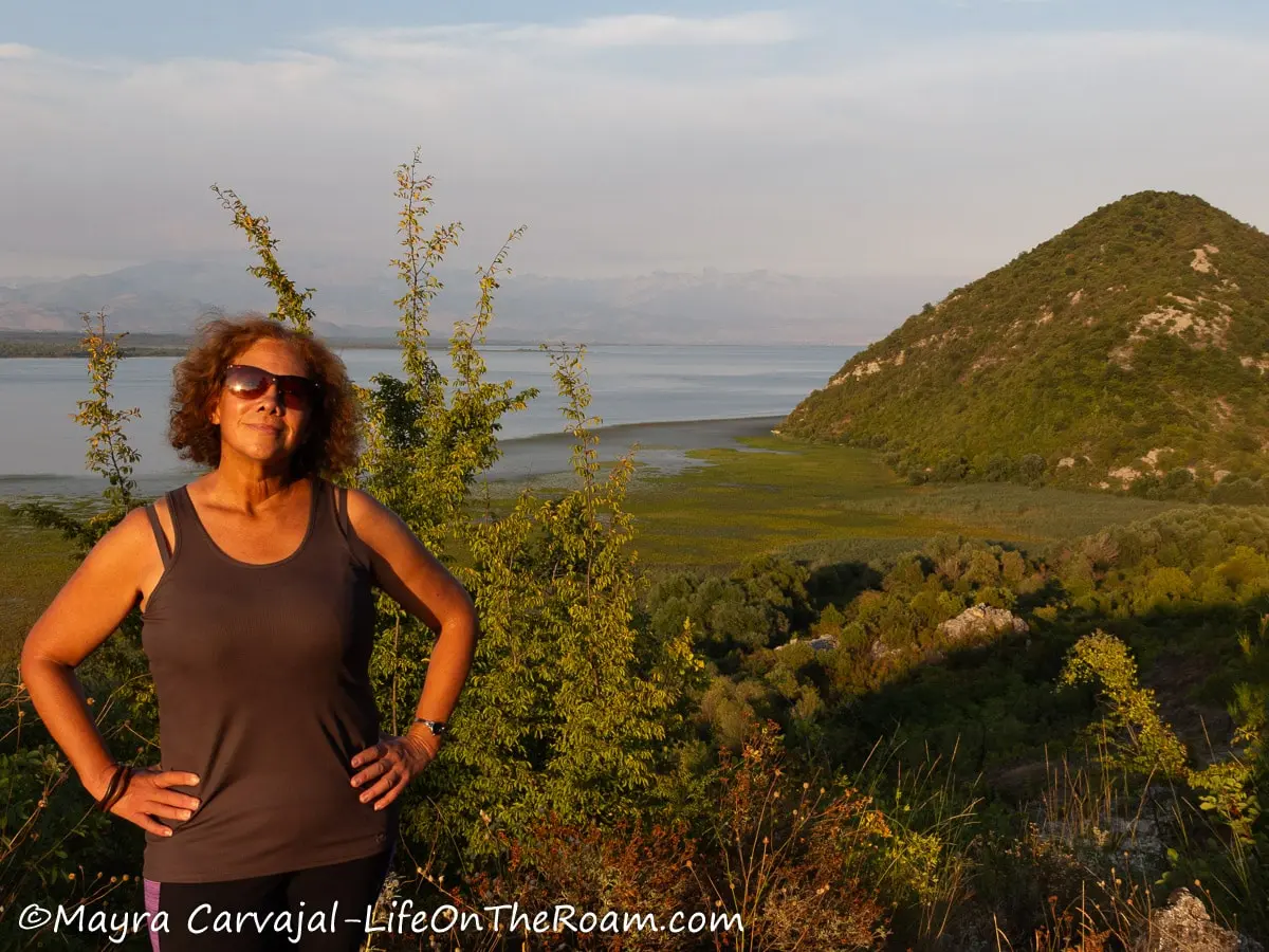 Mayra standing against a background with mountains and a lake