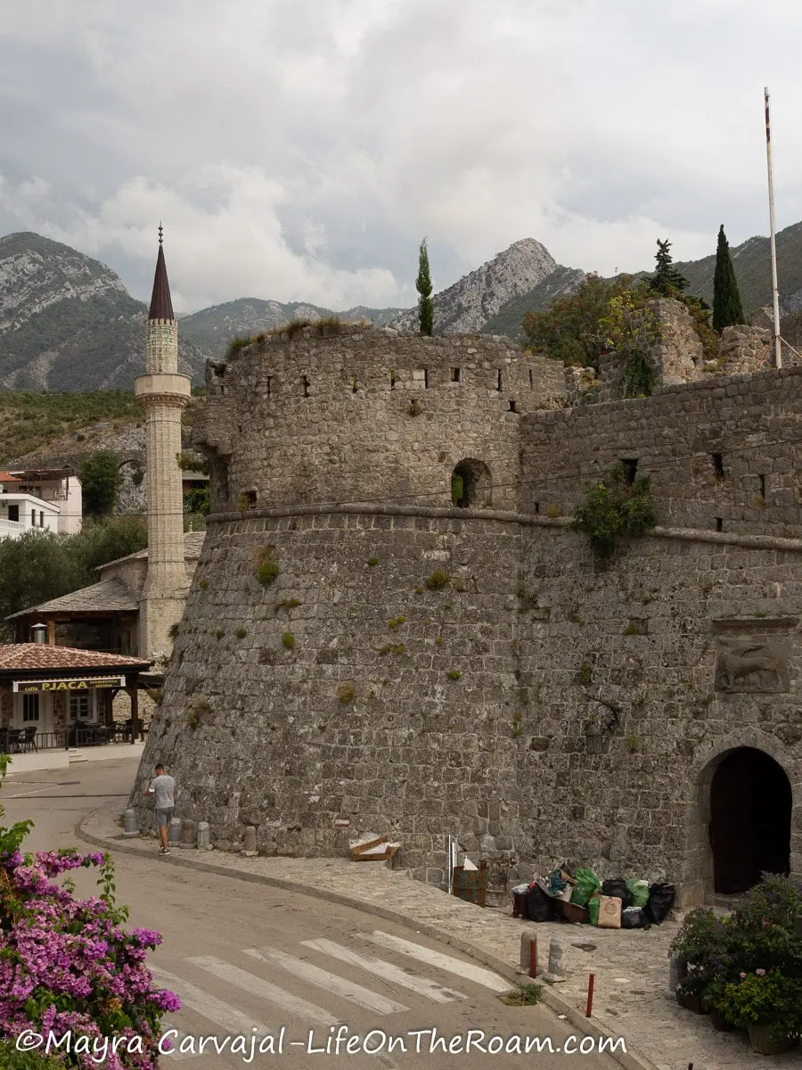 A circular bastion on a fortified wall with an arched entrance door