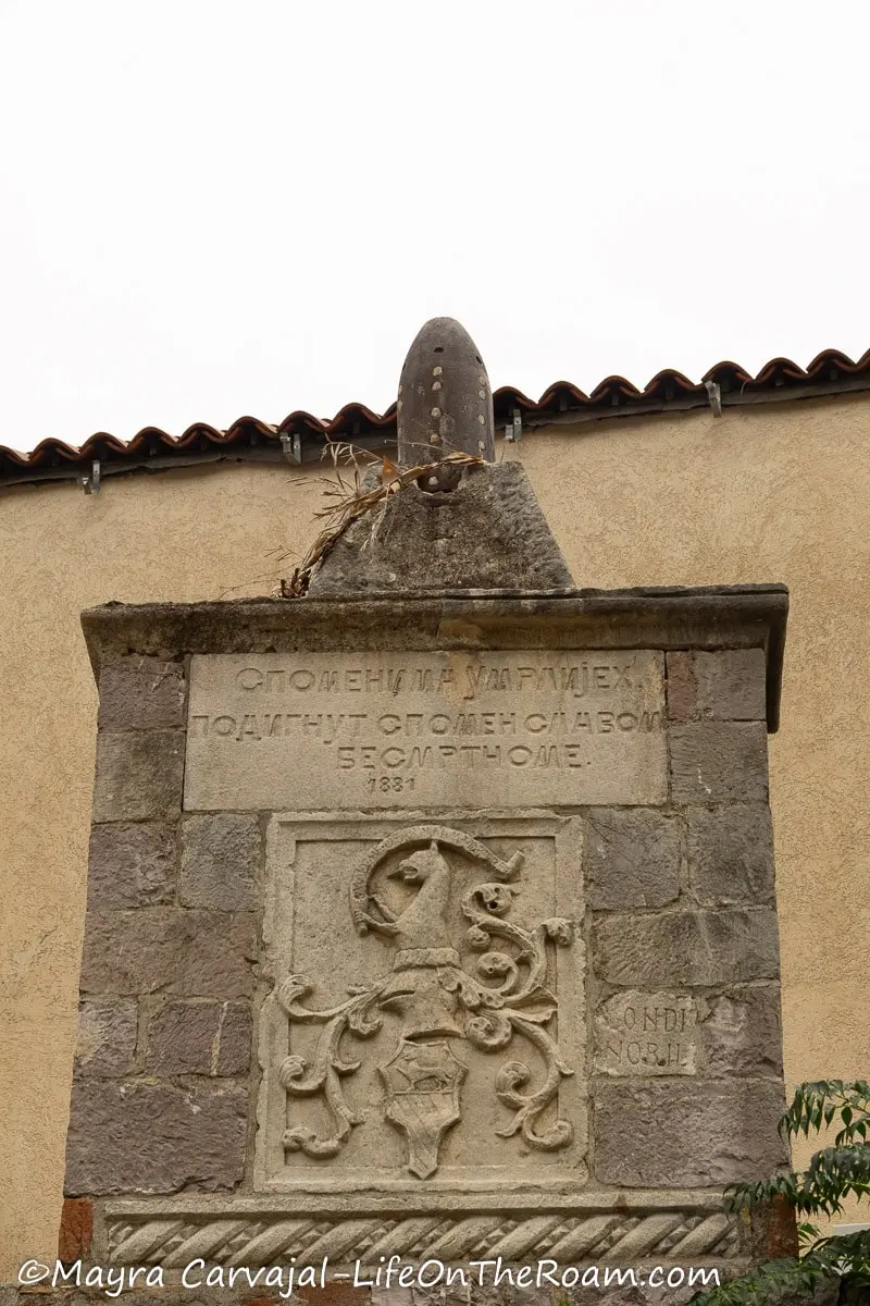 A stone marker with an inscription in Cyrillic and a relief with curves 