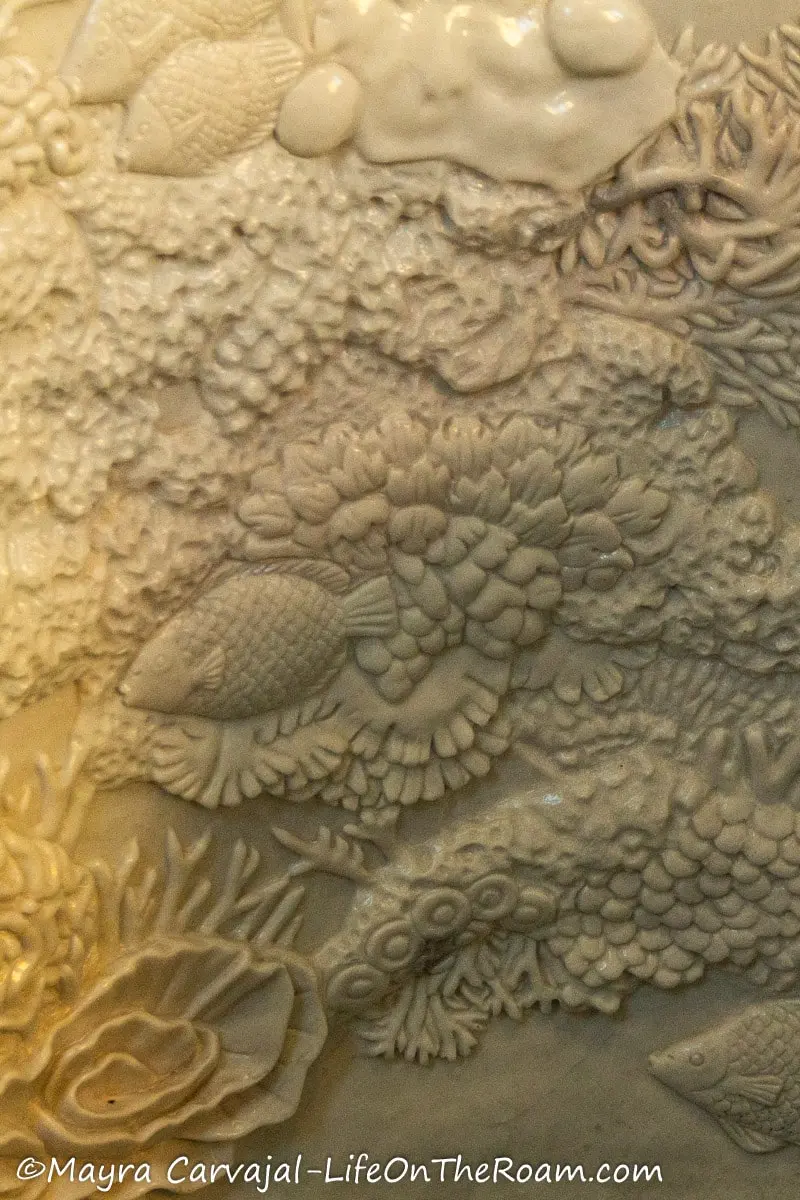 A white marble surface carved with fish, coral