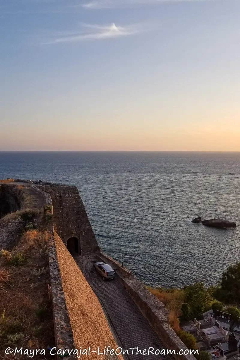 View of the sea from a fortress wall and a gate at the bottom