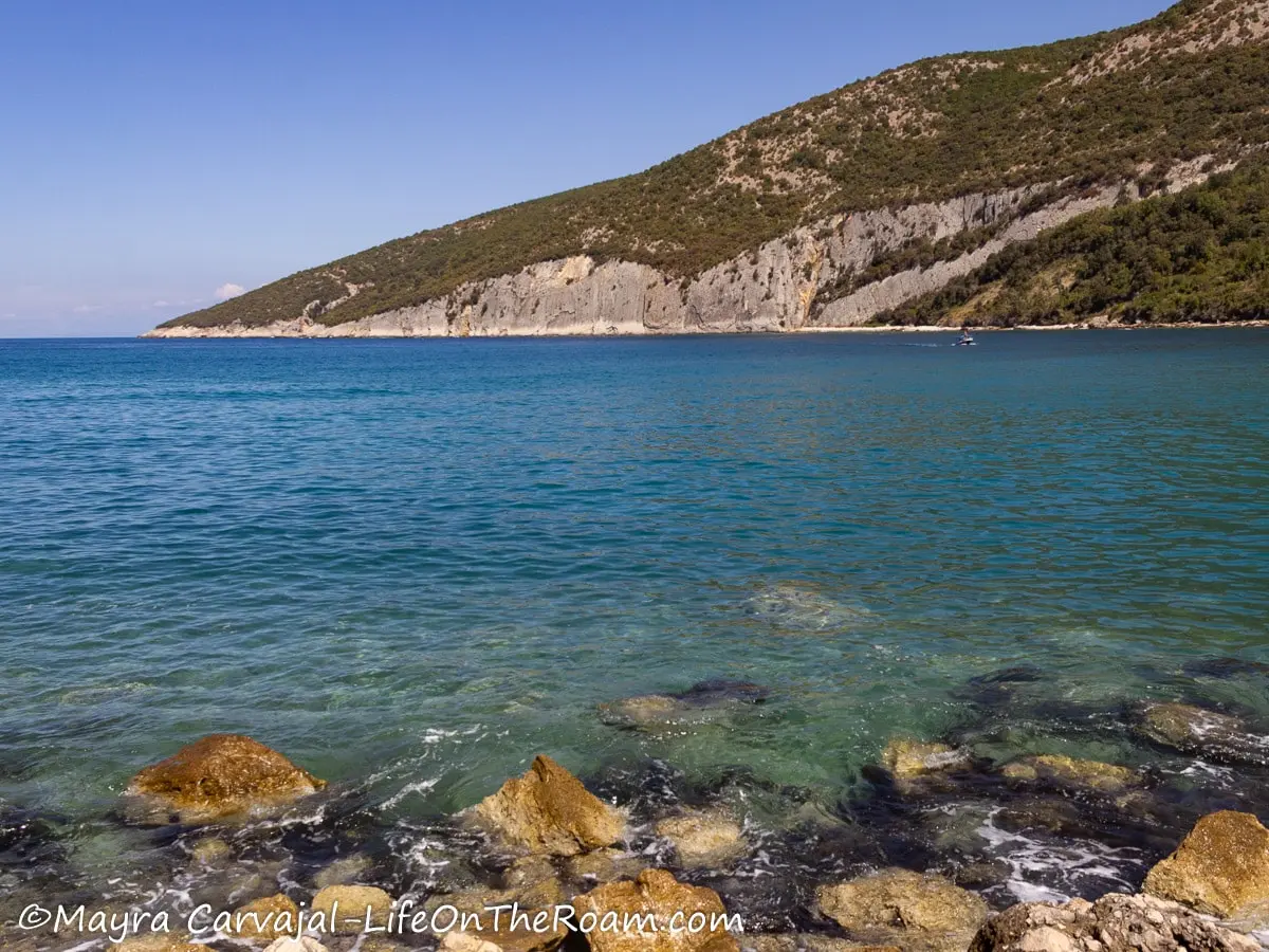 View of a hill going down to the sea from a rocky shore