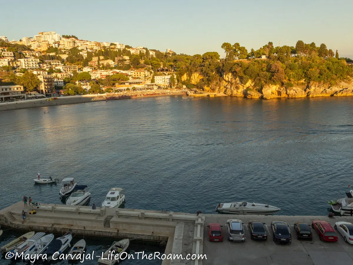 Aerial view of a coastal city at sunset with a marina right below