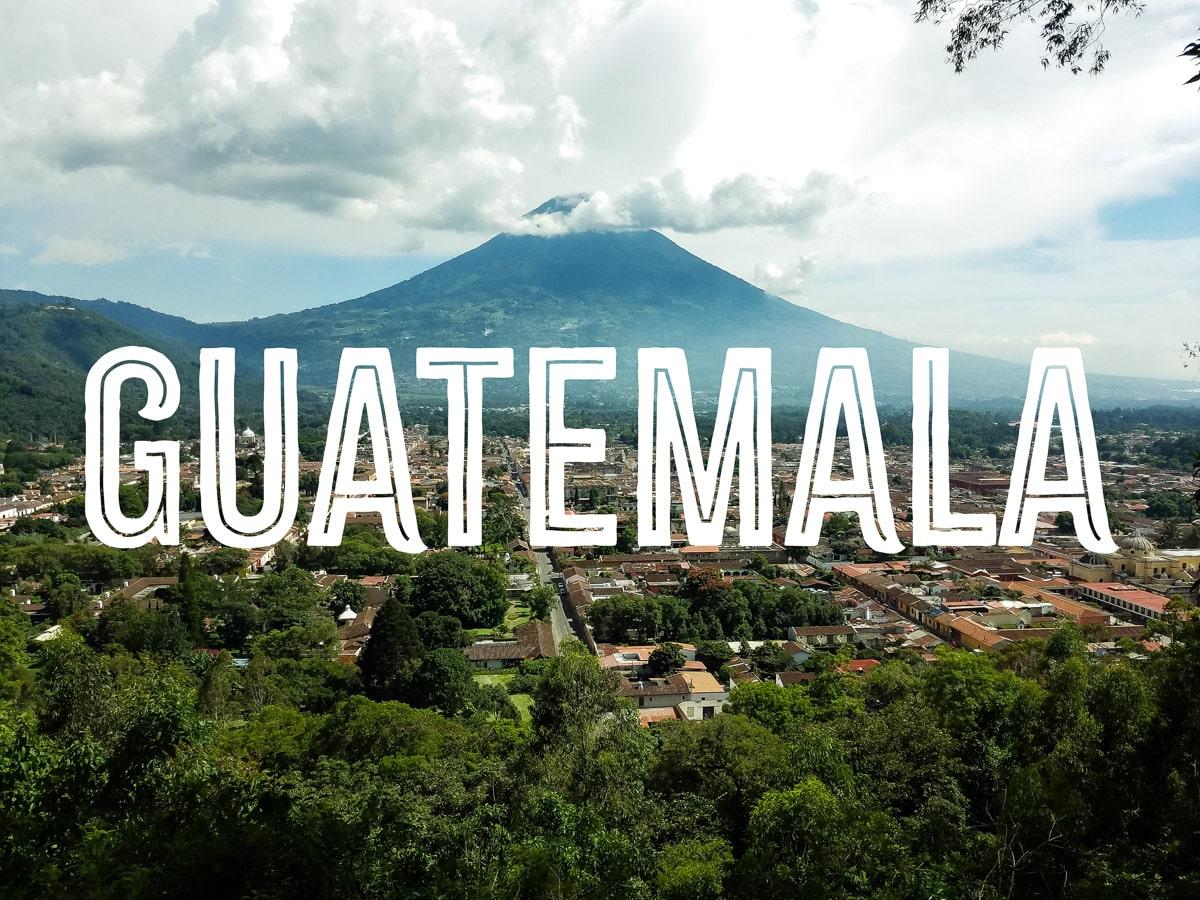 High view of a colonial town with a volcano in the background and the word GUATEMALA