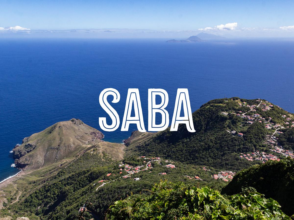 View of a coastline with hills and a small village from a high viewpoint, with the word SABA