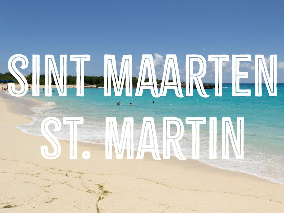 A beach with powdery sand and turquoise waters with the words SINT MAARTEN ST MARTIN