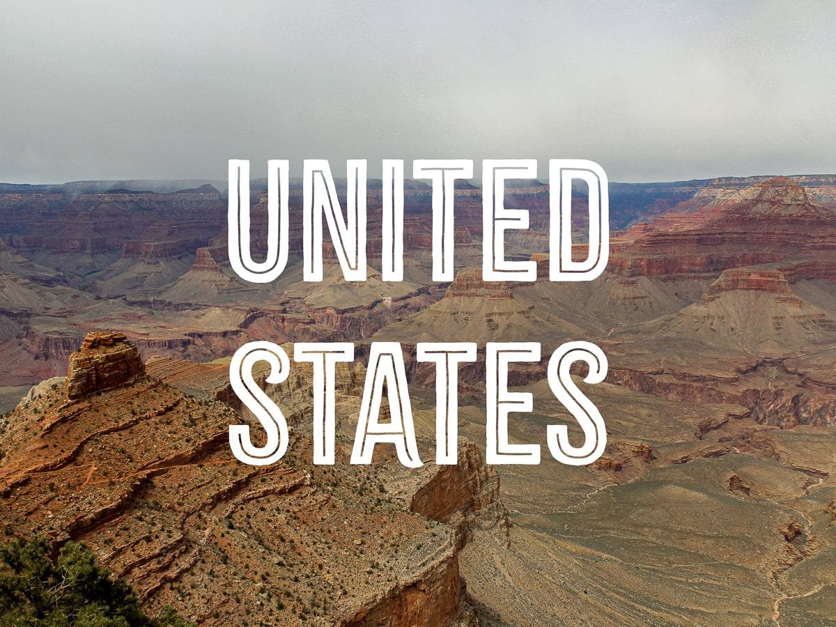 An immensely huge canyon with reddish,beige, and orange layers, with the words UNITED STATES