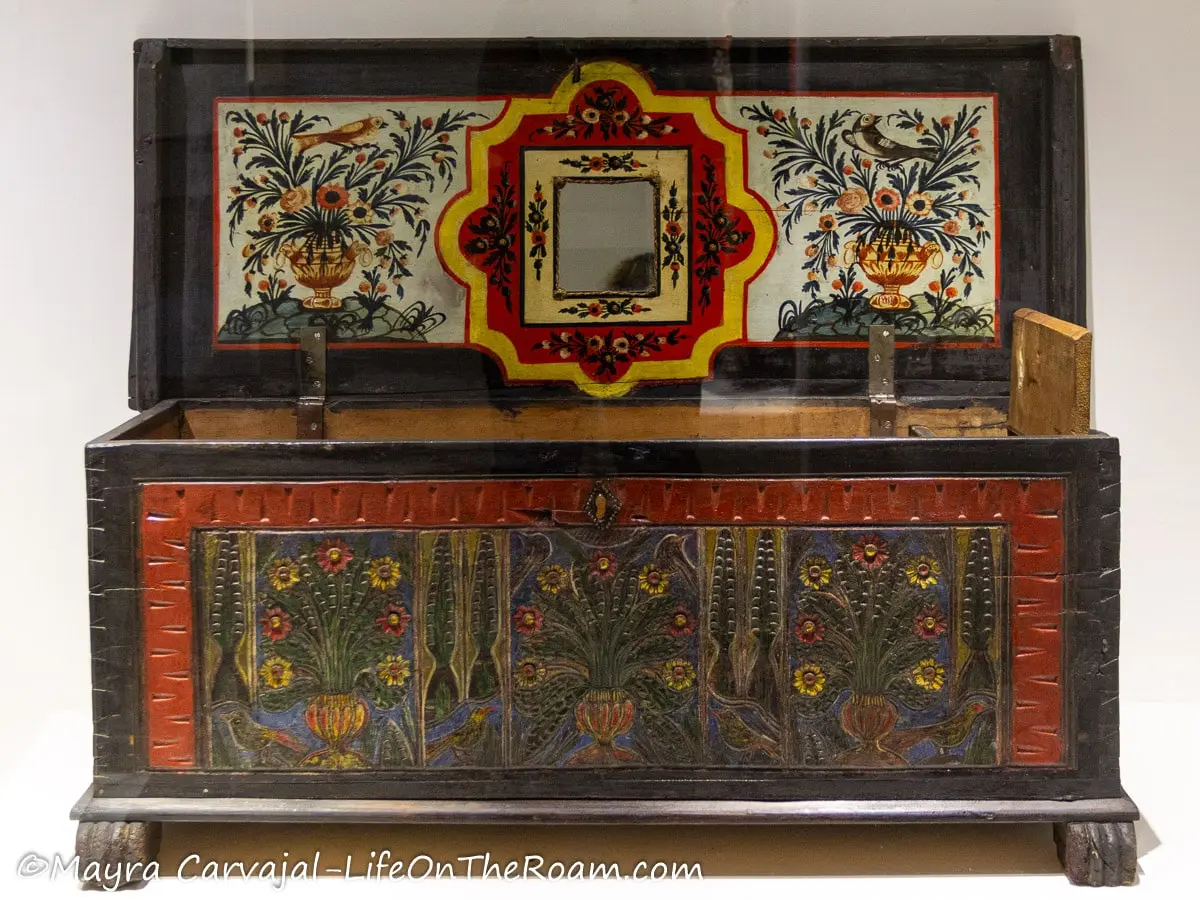 A traditional wooden chest decorated with flower motifs and painted in vivid colours