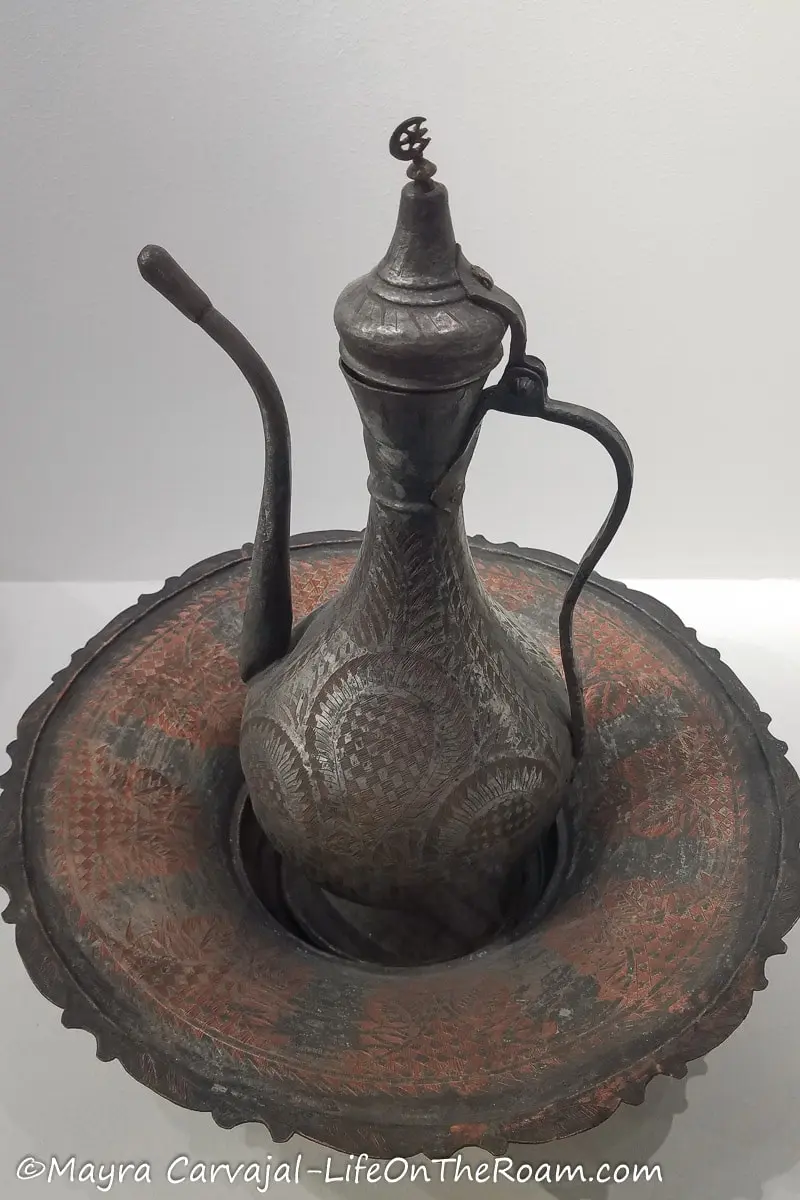 Ornamented metal round dish with a pitcher