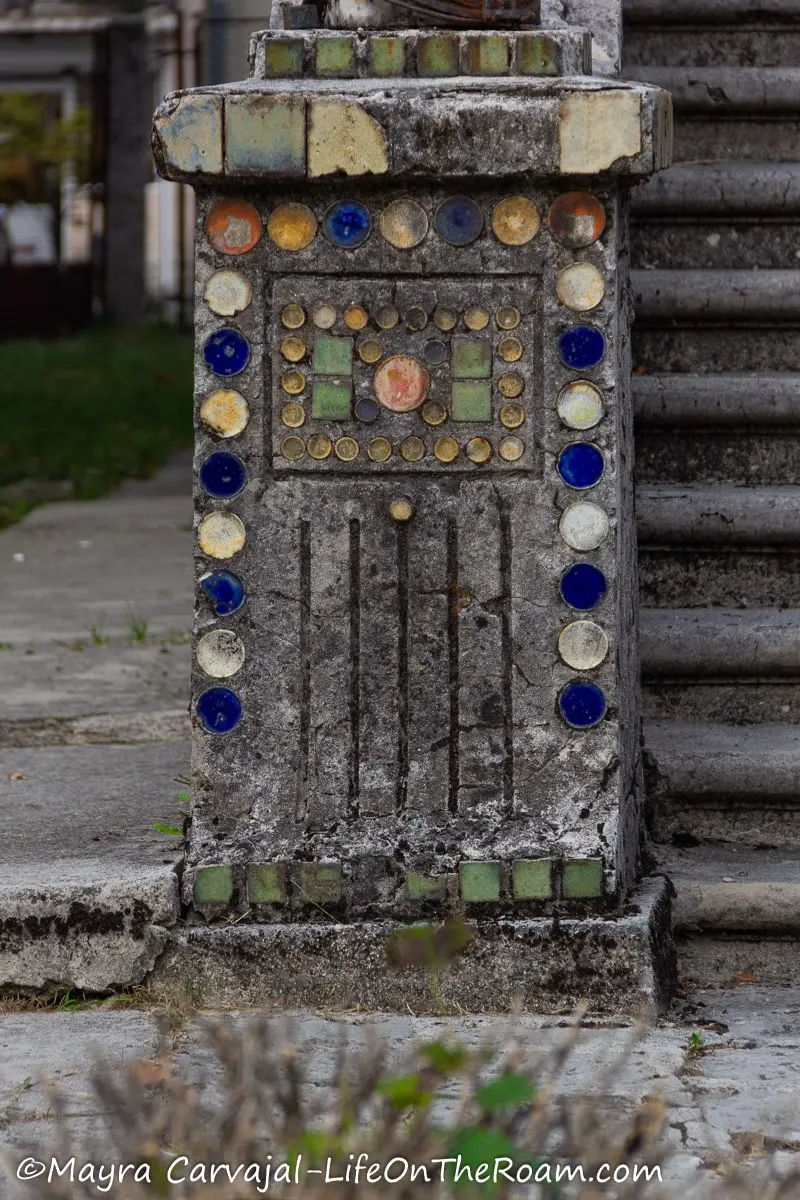 Multicolour round and square tiles in a concrete post