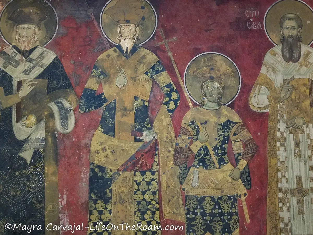 Reproduction of a church fresco depicting religious figures and leaders carrying crosses