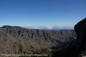 A mountain ridge with more mountains in the distance in a sunny day