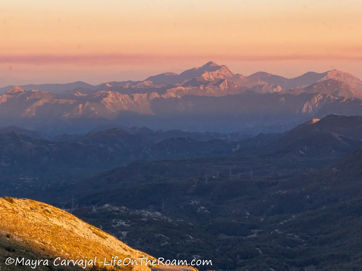 A sunset illuminating a mountain range and valley.