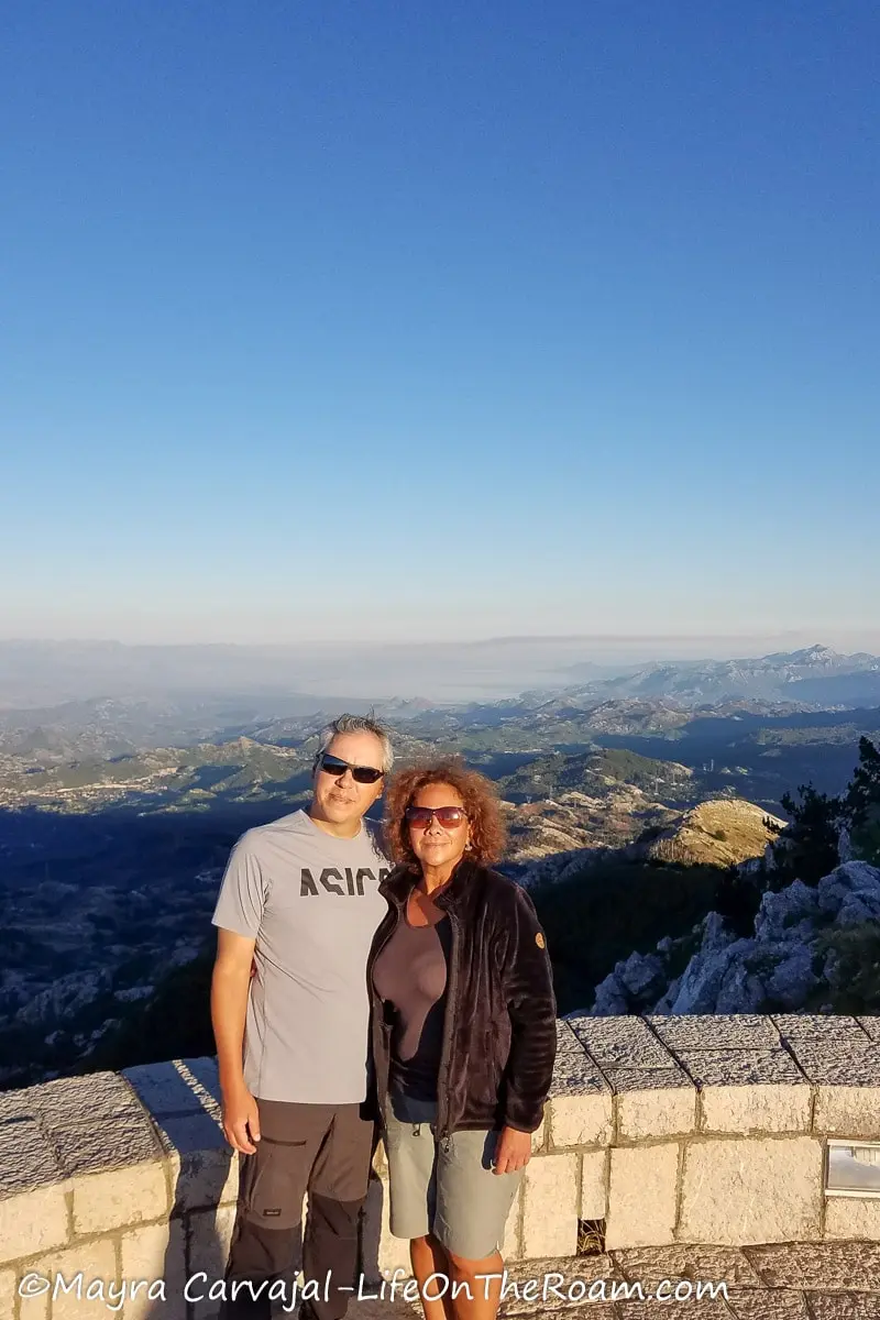 A couple standing at a lookout high up in a mountain system