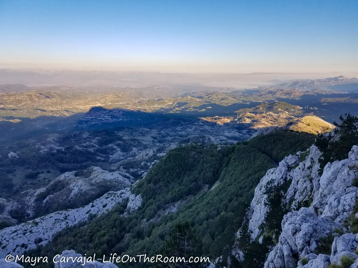 View of a mountain system partially covered in vegetation at sunset time