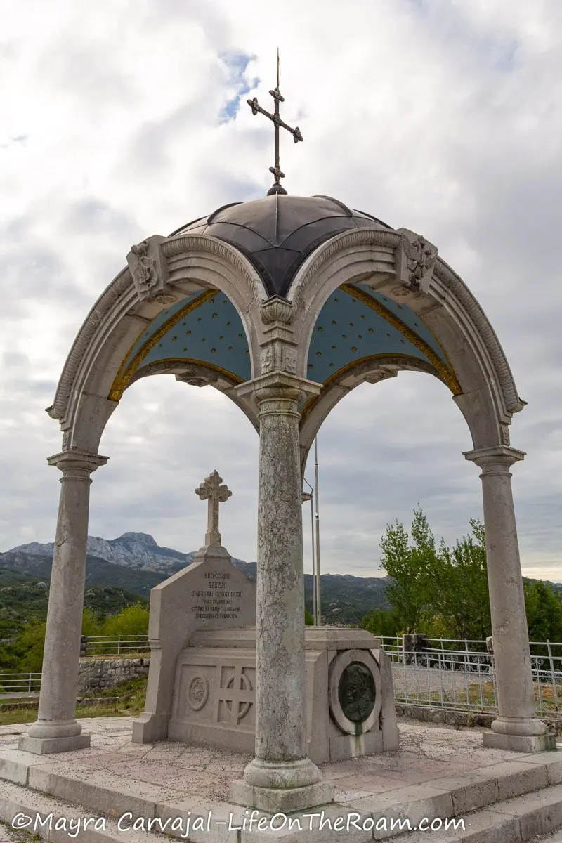 A mausoleum with a dome supported by four arches, covering a tomb