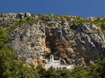 A big rectangular white building with a tall tower inside a cliff