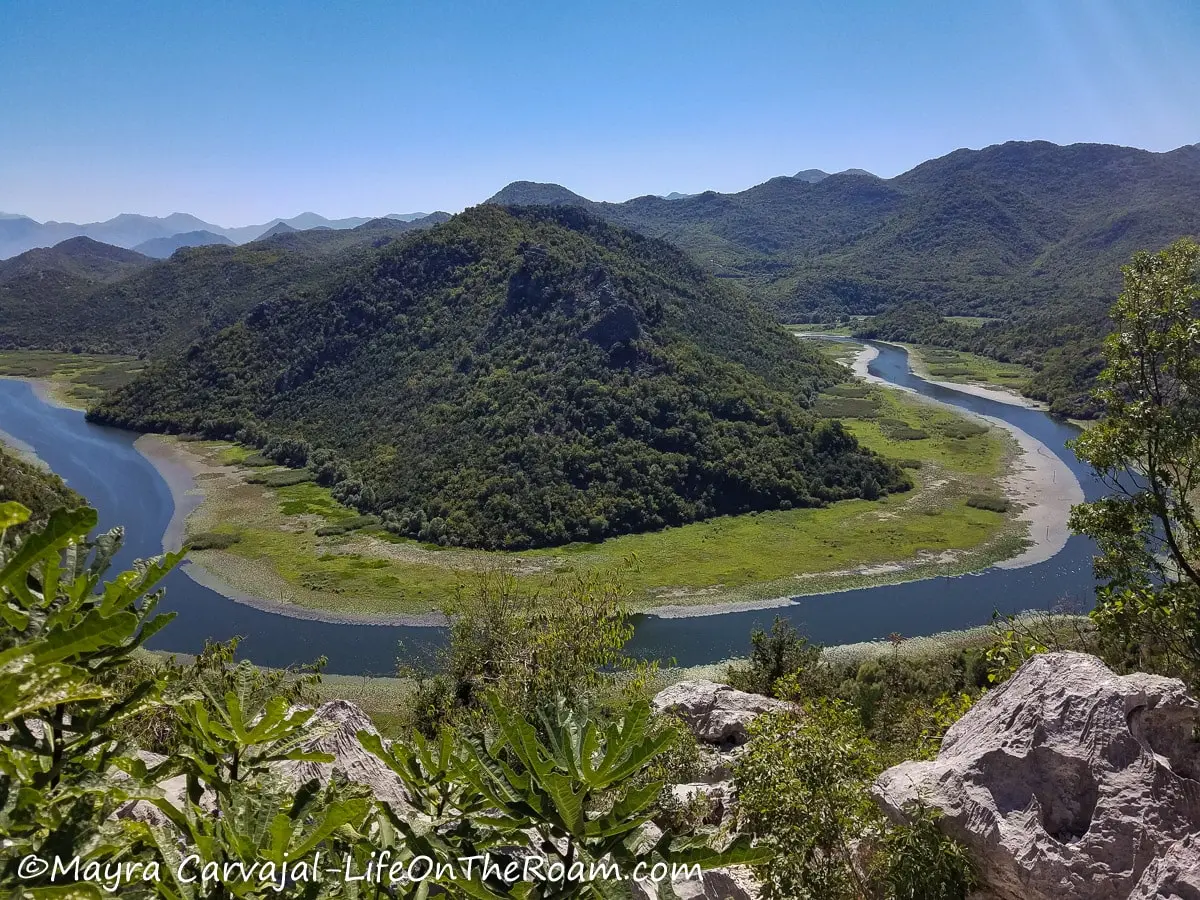 A horseshoe shape section of a river with a tree-covered hill in the centre