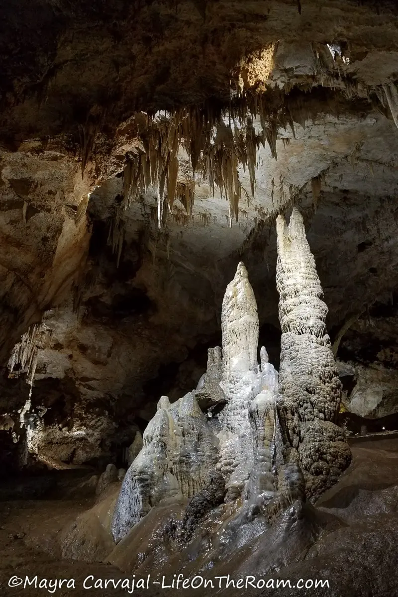 Big stalagmites inside a cave illuminated by a spotlight